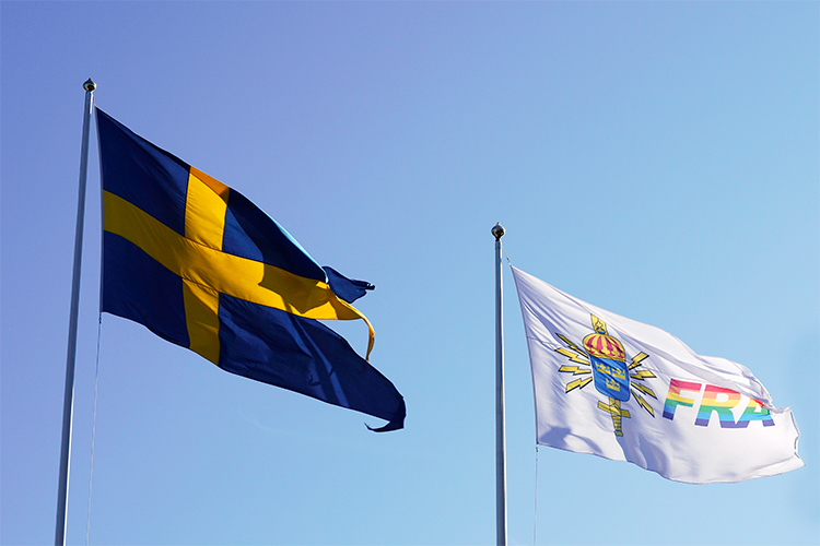 Flagga med FRA skrivet i regnbågsfärger.