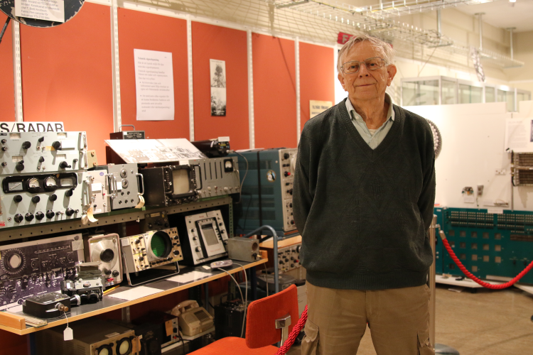 Man framför vägg med teknisk utrustning.