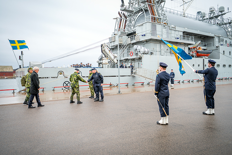 Högtidligt välkomnande av Kungen framför fartyg.